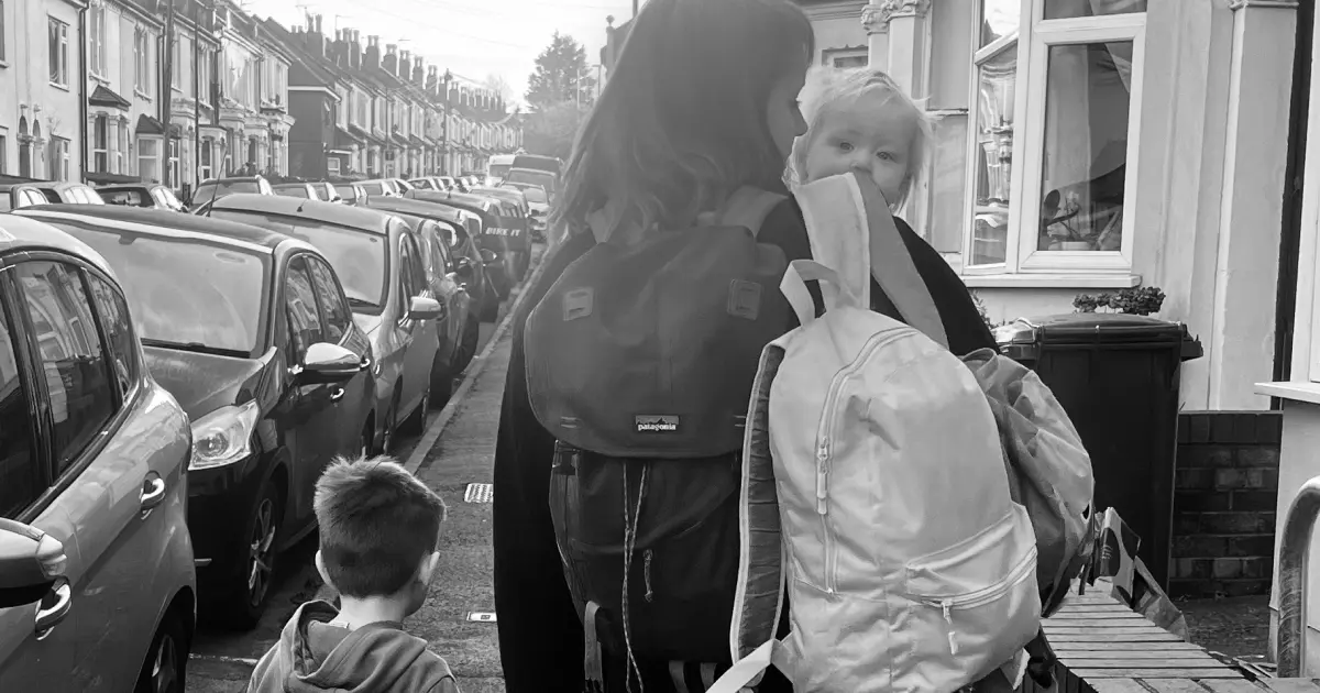 Kate walking to nursery with two children and 3 backpacks